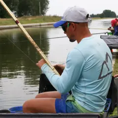 Wędkarz z grubą żyłką wędkarską przygotowuje się do łowienia na kanale.
