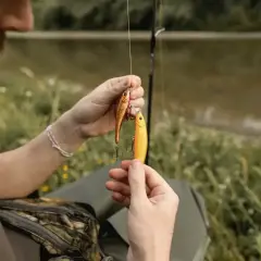 Wędkarz przygotowuje przynęty, by pokazać, jak łowić na spinning.